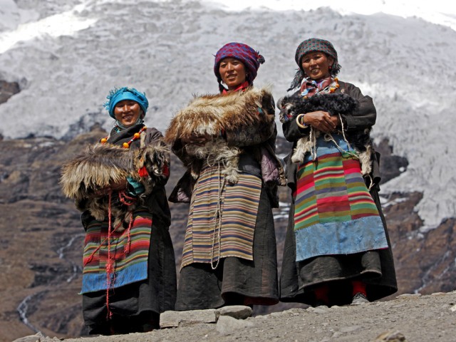Three Tibetan women in traditional dresses